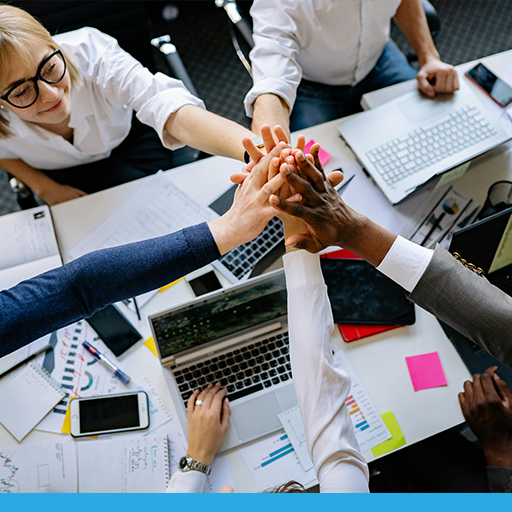 Partner team hands stacked together over technology work